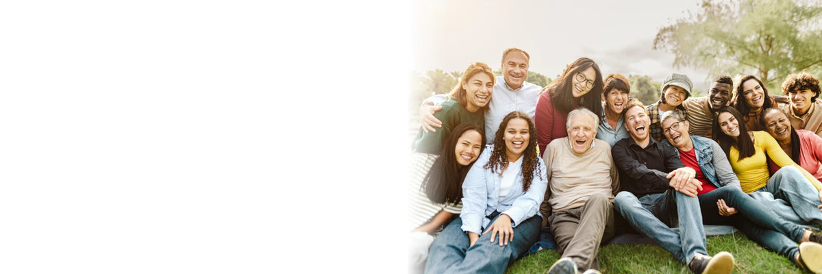 Groupe souriant de personnes de tous âges assises dans l'herbe